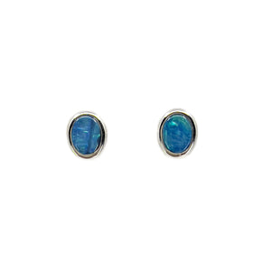 A pair of 14ct white gold earrings featuring oval-shaped doublet Australian opals, set in a bezel setting to highlight their vibrant blue and green colors, against a plain white background. | Fremantle Opals