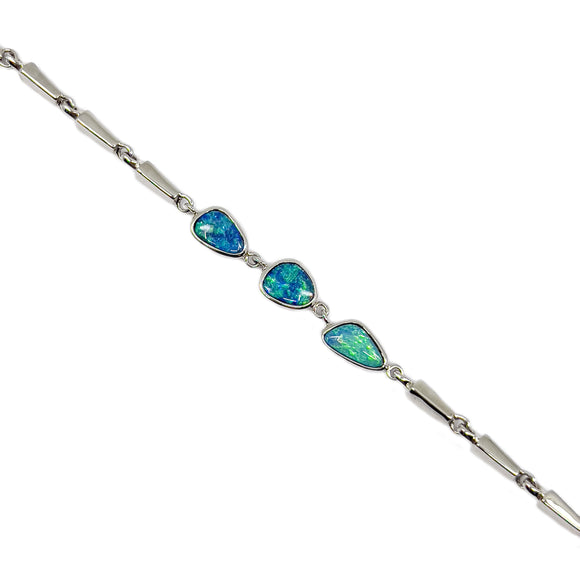 A sterling silver bracelet with a series of free-form cut doublet opals in vibrant blues and greens, set in simple bezels, with a secure clasp and a polished finish. The bracelet is photographed against a white background to highlight the colorful play of light within the opals.  | Fremantle Opals