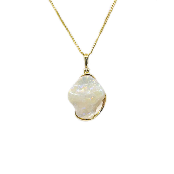 An exquisite 18ct yellow gold pendant with a unique, free-form solid white opal exhibiting a soft play of colors, paired with a complementary gold-plated chain. | Fremantle Opals