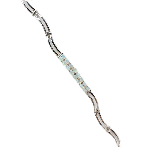 A sterling silver bracelet featuring a line of claw-set solid white opals, each emitting a soft iridescent glow. | Fremantle Opals