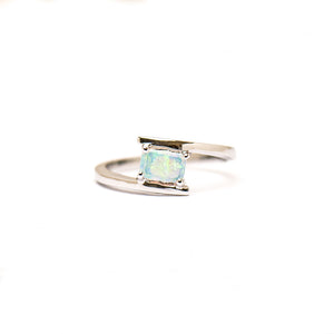 Sterling silver ring with a rectangle-cut solid white opal, claw-set atop a contemporary wrap style band, showcasing the opal's unique color variations. | Fremantle Opals