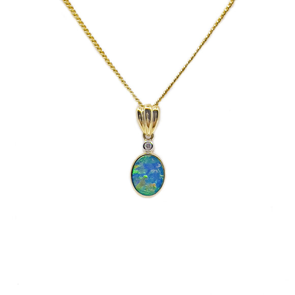 Elegant 9ct yellow gold pendant featuring a vibrant bezel-set Australian doublet opal with blue and green hues, topped with a sparkling diamond accent. | Fremantle Opals