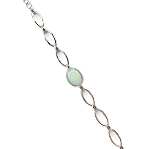A sterling silver bracelet with a series of oval, bezel-set solid white opals showing a luminous play of colors, linked by elegant silver connectors. | Fremantle Opals